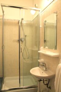 uma casa de banho com um chuveiro e um lavatório. em Albergo Nella em Imperia