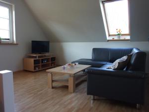 Sala de estar con sofá azul y mesa de centro en Ferienwohnung am Betschkamp, en Schneverdingen