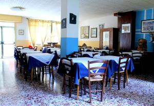 a room with tables and chairs with blue table cloth at Albergo Nella in Imperia
