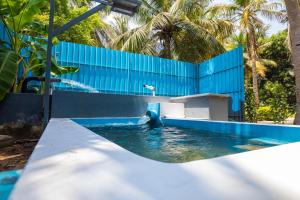 a pool with a water slide in front of a blue fence at Shiv Sakthi villa in Kumbakonam