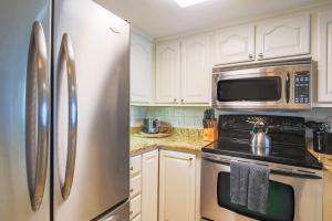 a kitchen with white cabinets and a stainless steel refrigerator at Seaside Therapy~ in Seabrook Island +42 photos
