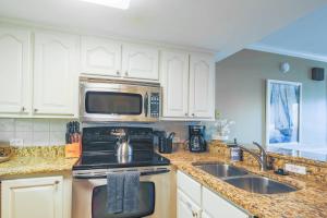 a kitchen with a stove and a microwave at Seaside Therapy~ in Seabrook Island