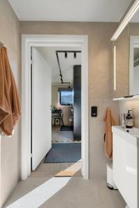 a bathroom with a door leading to a dining room at Premium Studio by Arctic Seasons - A Cozy Luxury Escape at the Top of Tromsø in Tromsø