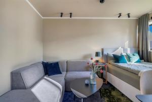 a living room with a couch and a table at Premium Studio by Arctic Seasons - A Cozy Luxury Escape at the Top of Tromsø in Tromsø