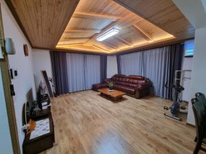 a living room with a leather couch and a table at 꽃이피다 in Kulchŏn