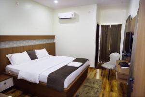 a bedroom with a bed and a television in a room at Hotel V R Grand in Bhadrāchalam
