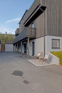 two chairs sitting in a parking lot next to a building at Premium Studio by Arctic Seasons - A Cozy Luxury Escape at the Top of Tromsø in Tromsø