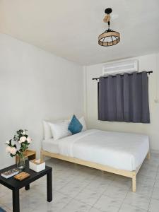 a bedroom with a bed and a table at Friends Retreat Phuket in Ban Bo Han