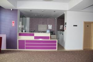 a kitchen with purple and white cabinets in a room at Kharisma Hotel in Mamaia Nord