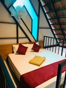 a bedroom with a bed with red pillows and a fan at Regalia Wayanad in Kalpetta +35 photos