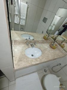 a bathroom with a sink and a toilet at Apart Atlantic City Service Ondina in Salvador