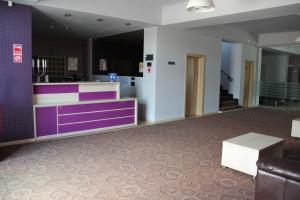 an empty lobby with a purple and white counter at Kharisma Hotel in Mamaia Nord +52 photos