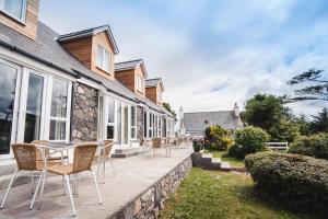a patio with chairs and tables on a house at Kirklea Island Suites in Tarbert