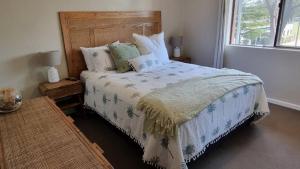a bedroom with a bed with a wooden headboard at Lazy Dayz On Booner! in Hawks Nest +4 photos