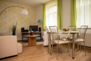 a living room with a dining room table and chairs at Ferienwohnungen "Am Mühlteich" in Radeburg
