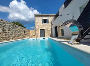 basen z błękitną wodą przed domem w obiekcie Villa Galant with Pool & Sauna Maružini w mieście Maružini