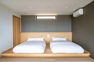 a bedroom with two beds with white sheets at SETO CLAS for SLEEP B棟 in Takamatsu