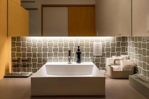 a bathroom with a white sink and a tile wall at SETO CLAS for SLEEP B棟 in Takamatsu +37 photos