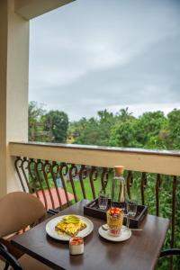 a table with two plates of food on a balcony at The Palm House in Canacona +33 photos
