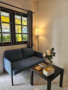 a living room with a blue couch and a table at Friends Retreat Phuket in Ban Bo Han