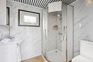 a white bathroom with a shower and a sink at Bus Life Sleep Play & Farm Views in Fyansford