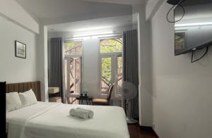 a bedroom with a bed and a window with a fan at Hanoi Old Quarter Hotel and Spa in Hanoi
