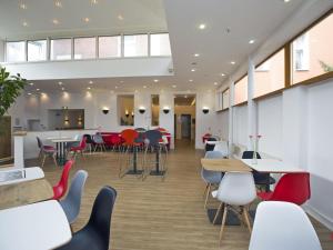 uma cafetaria com mesas e cadeiras num edifício em ibis Berlin City Süd em Berlim