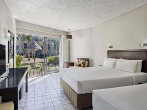 a hotel room with two beds and a balcony at Mercure Nadi in Nadi +44 photos