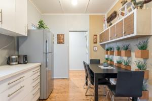 uma cozinha e sala de jantar com mesa e cadeiras em Cozy Private Single Room in Carramar - Nearby Station & Shops - Shared Bathroom em Villawood