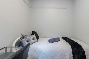 um quarto com uma cama com travesseiros em Cozy Private Single Room in Carramar - Nearby Station & Shops - Shared Bathroom em Villawood