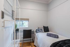 um pequeno quarto com uma cama e uma escrivaninha em Cozy Private Single Room in Carramar - Nearby Station & Shops - Shared Bathroom em Villawood mais 18 fotografias