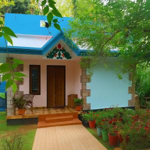 a small house with a blue roof at BHASKAR VILLA RESORTs in Varkala