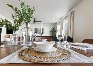 a dining room table with a vase of flowers and glasses at 6BR Retreat with Playground Basketball & Sleeps 22 in Star