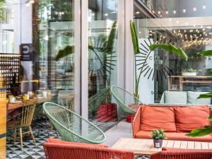 a patio with chairs and a couch in front of a store at Ibis Barcelona Plaza Glòries 22@ in Barcelona +76 photos