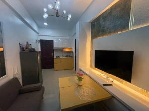 a living room with a large flat screen tv on a wall at Near Mactan International airport Condo with Private Entrance and Shared Pool in Gun-ob