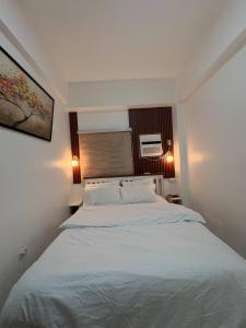 a bedroom with a large white bed with two pillows at Near Mactan International airport Condo with Private Entrance and Shared Pool in Gun-ob +25 photos