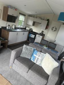 a living room with a couch and a kitchen at The Mayflower in Skipsea