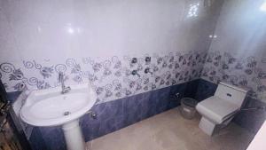 une salle de bain avec un lavabo et des toilettes dans l'établissement Badal Valley Resort, à Kumbhalgarh 23 autres photos