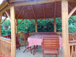 a table and chairs under a wooden gazebo at Leander Apartman in Sárvár