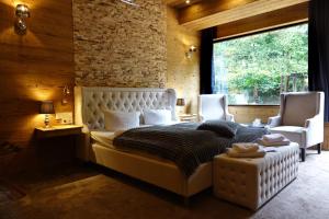 ein Schlafzimmer mit einem großen weißen Bett und zwei Stühlen in der Unterkunft Wolfstein - Le Boutique Hotel in Bad Harzburg