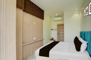 a bedroom with a bed and a wooden wall at Super Townhouse Oak Prayagraj Central Railway Junction Formerly Hotel Ballians in Prayagraj +23 photos