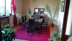 a dining room with a table and chairs on a pink rug at Pension Casa Contelui in Râşnov