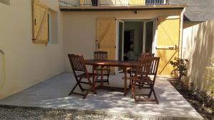 a wooden table and chairs on a patio at Les Muguets in Villers-sur-Mer
