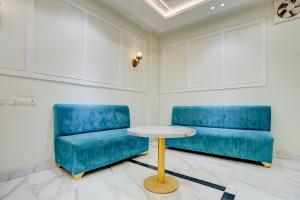 two blue chairs and a table in a room at Super Townhouse Oak Prayagraj Central Railway Junction Formerly Hotel Ballians in Prayagraj