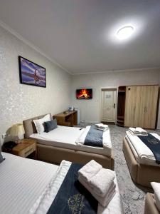 a hotel room with two beds and a tv at Afsona Hotel in Bukhara +47 photos