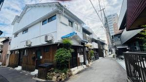 un edificio blanco al costado de una calle en サンハウス 2, en Osaka