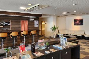 a lobby with a bar with a couch and chairs at Summit Views Hakuba in Hakuba