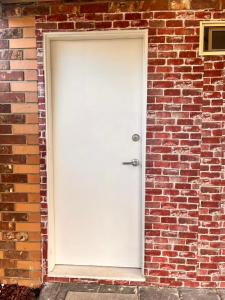 a white door in a brick wall at Bright & Quiet 1BR with Courtyard in Williams Landing +17 photos