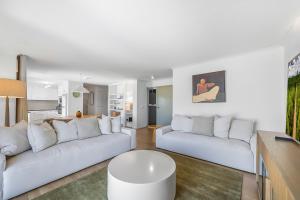 a white living room with two white couches at Oceanfront 3-Bed Retreat with Pool-Steps to Beach in Caloundra +14 photos