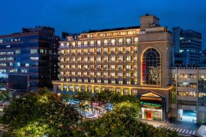 un edificio illuminato in una città di notte di Holiday Inn Hangzhou West Lake by IHG a Hangzhou